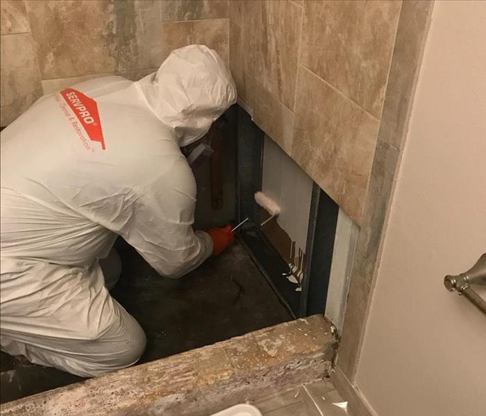 Restoration professional restoring a bathroom in a home after a storm
