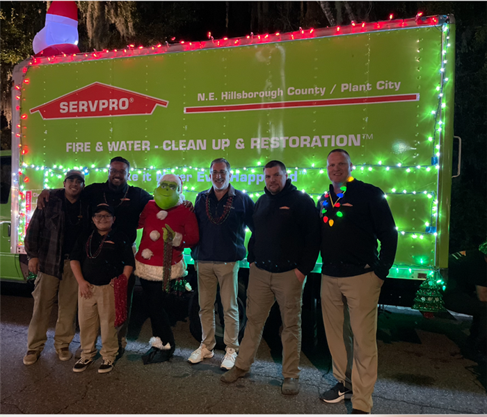 Team members posing for photos in front of the SERVPRO van.